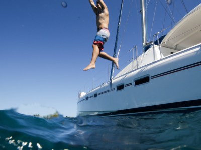 man jumping off catamaran in to water