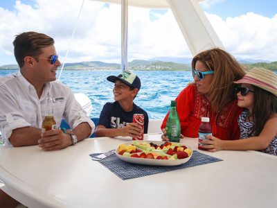 family having beverages & fruit on catamaran