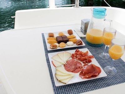 meat and cheese plate, dessert plate, and orange juice on catamaran