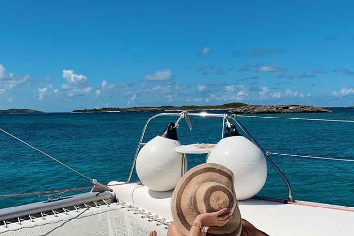 a blue and white boat sitting next to a body of water