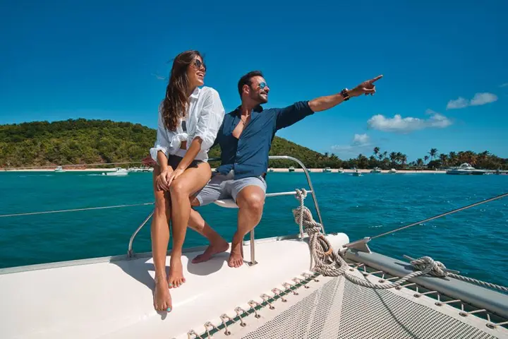 a woman sitting on a dock next to a body of water