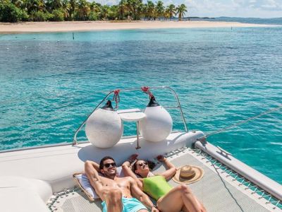 a woman sitting next to a body of water
