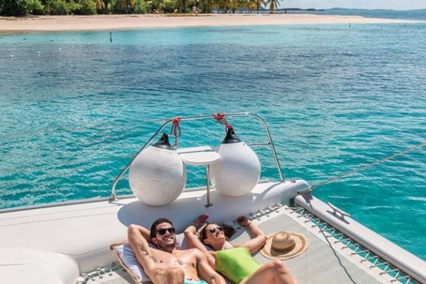a woman sitting next to a body of water
